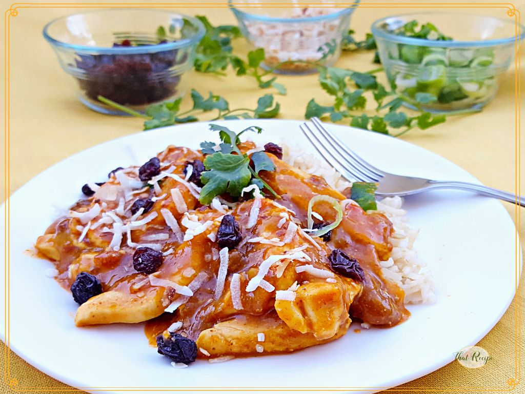 chicken curry on a plate with condiments