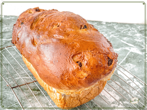 loaf of cinnamon swirl raisin bread on a cooling rack.