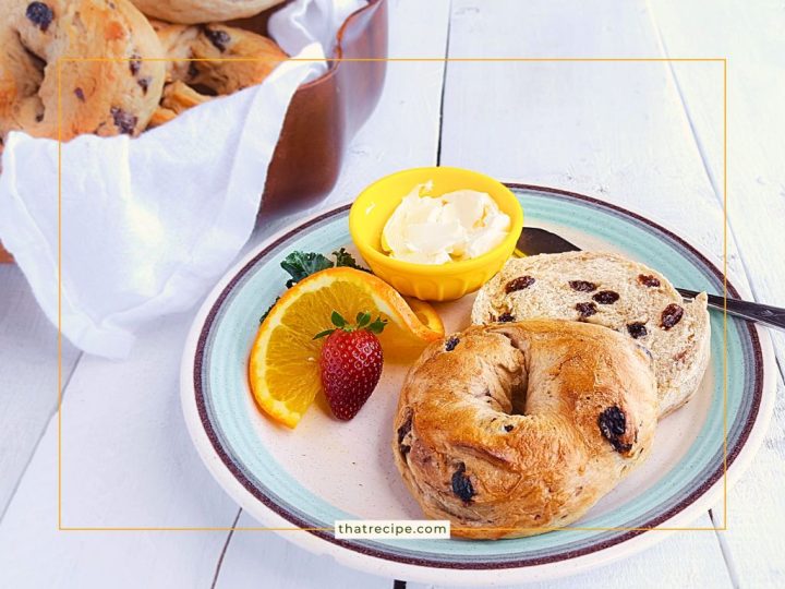 cinnamon raisin bagel on a plate with cream cheese orange slice and strawberry