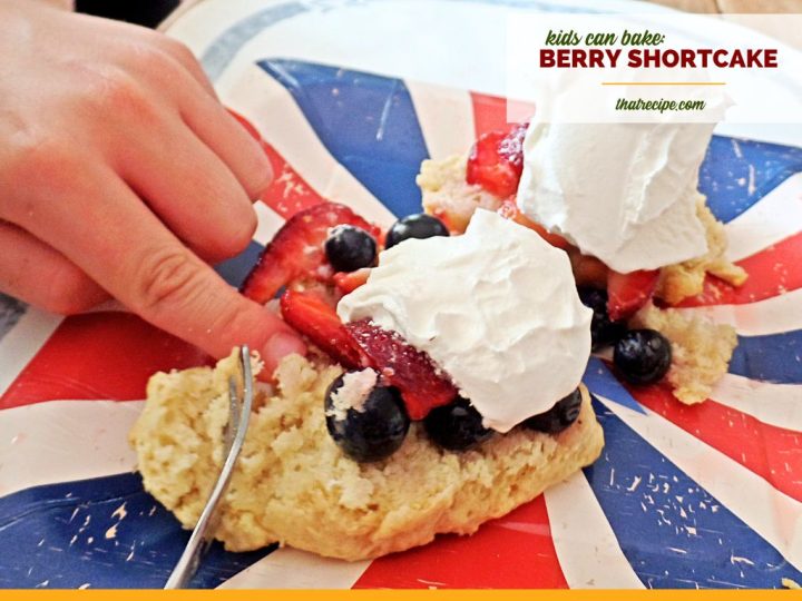 child hand cutting berry shortcake