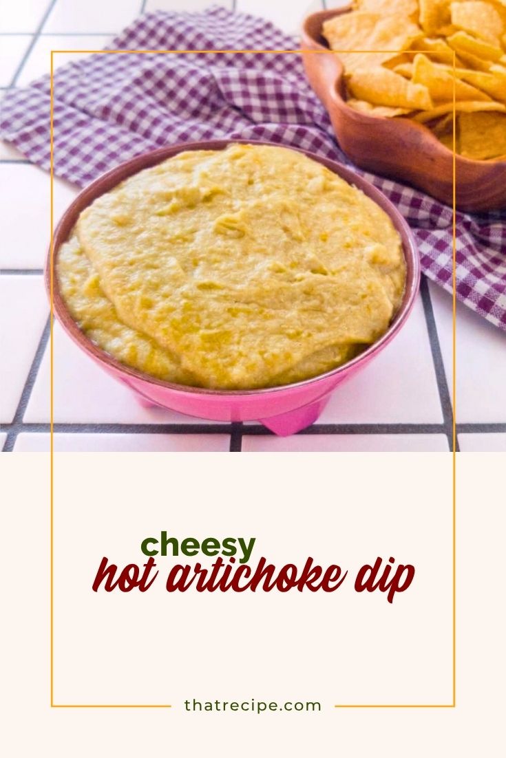 hot artichoke dip in a bowl next to tortilla chips