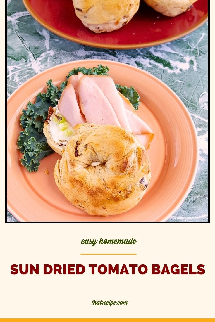 bagel sandwich on a plate with text overlay "sun dried tomato bagels"