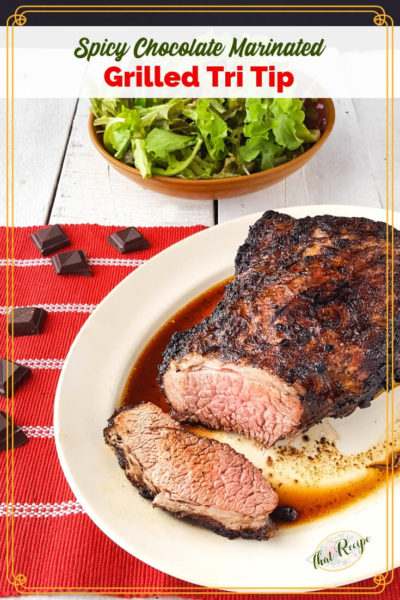 tri tip roast on a plate with a salad and chocolate pieces and text overlay "Spiced Chocolate Marinated Grilled Tri Tip"