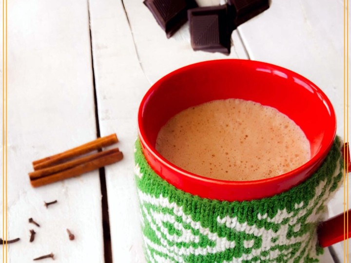 mug of hot chocolate with cinnamon cloves and chocolate blocks