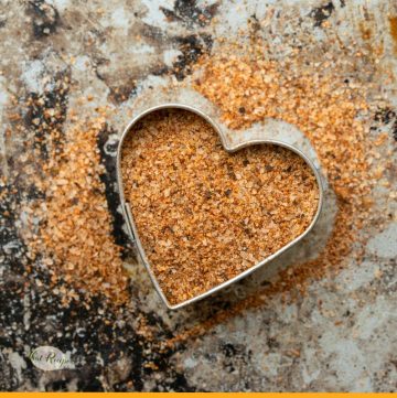 cajun seasoning mix on a marble background with a heart shaped cookie cutter
