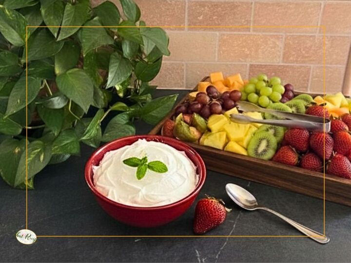 bowl of sweet creamy fruit dip with a tray of fruit