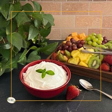 bowl of sweet creamy fruit dip with a tray of fruit