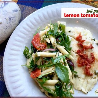 top down view of fish and pasta salad on a plate with text overlay "foil packet lemon tomato fish"