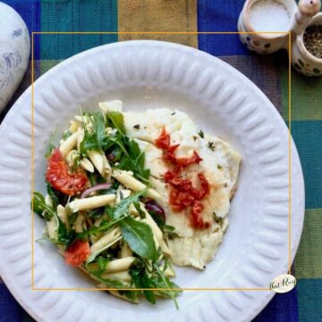 top down view of fish and pasta salad on a plate with top inset of fish in foil packet