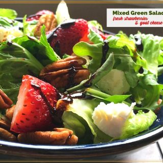 green salad with strawberries and goat cheese in a bowl