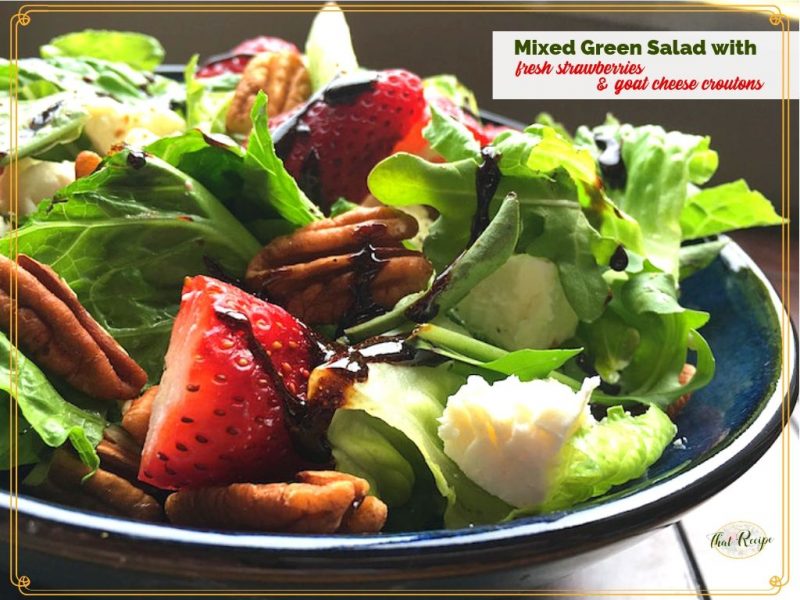 green salad with strawberries and goat cheese in a bowl