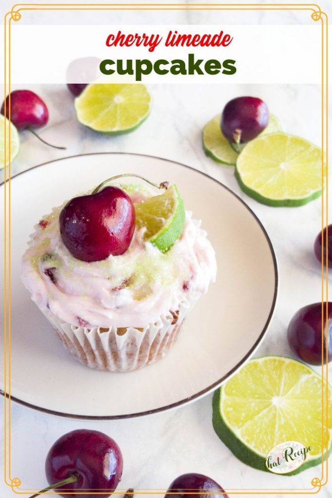 cherry limeade cupcake on a plate with fresh cherries and limes