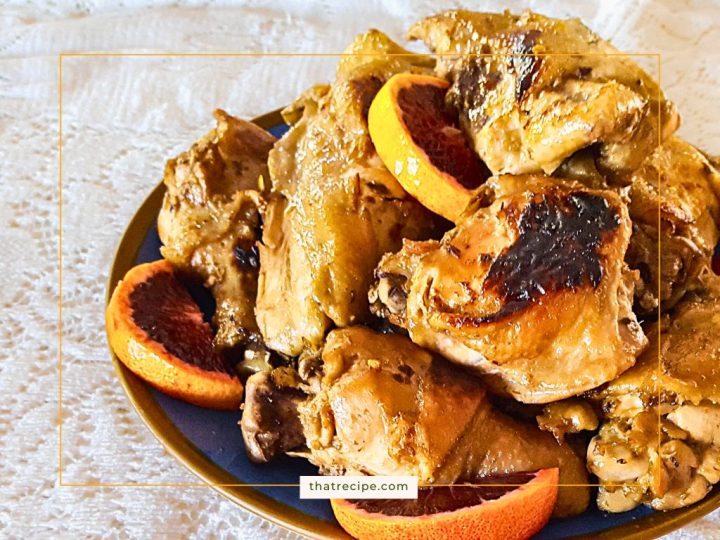 plate of cooked chicken pieces with blood orange slices