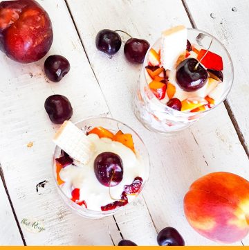 cheesecake parfaits on a table with summer fruits