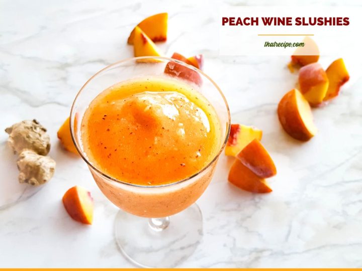 wine slushie on a marble backdrop with frozen peaches and ginger and text overlay "ginger peach wine slushies"