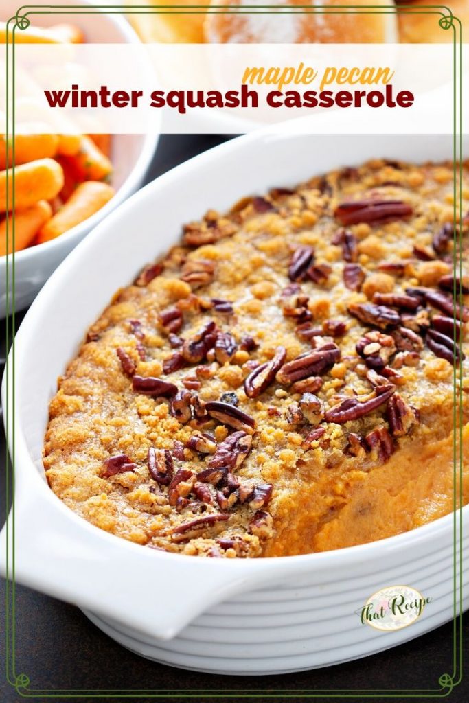 squash casserole on a table with carrots and rolls