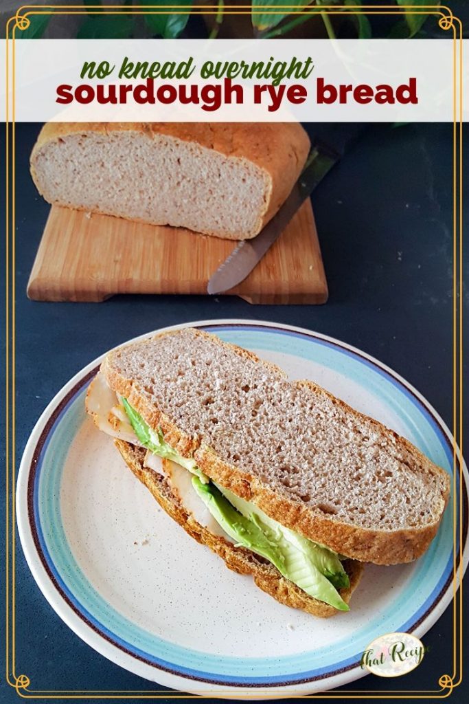 turkey and avocado sandwich on rye bread with loaf of ry bread in the background and text overlay "sourdough rye bread"