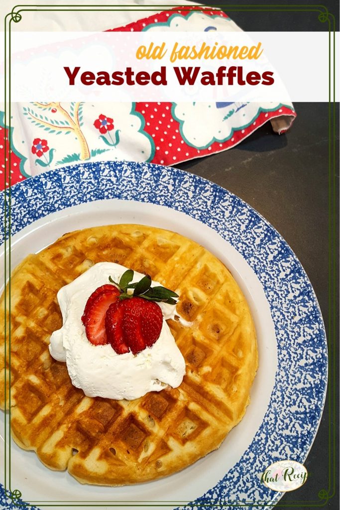 waffle on a plate topped with strawberry and whipped cream with text overlay "old fashioned yeasted waffles"