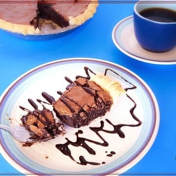 chocolate pie on a plate with cup of coffee and text overlay "fudgy brownie pie"