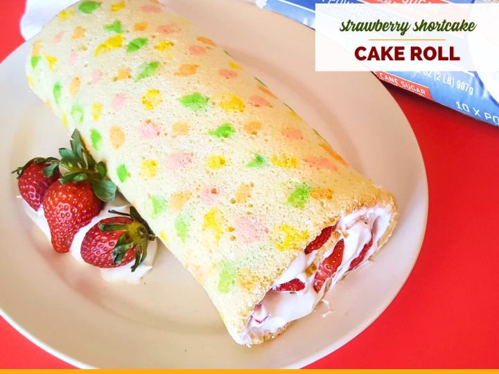 vanilla swiss cake roll with strawberries and whipped cream with text overlay "strawberry shortcake cake roll"