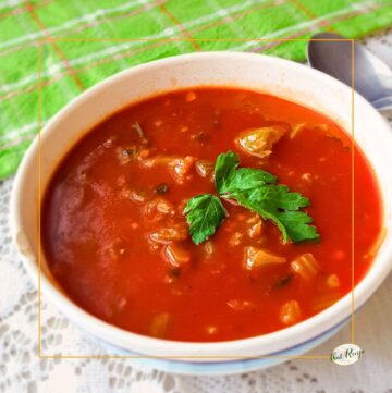 overhead view of tomato and celery soup in a bowl with a spoon