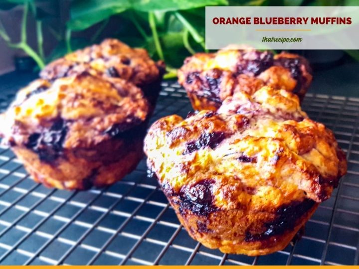 blueberry muffins on a rack with text overlay "orange blueberry muffin"