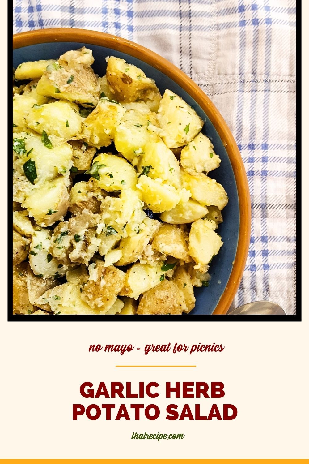 top down view of potato salad on a picnic blanket with text overlay "herb and garlic potato salad"
