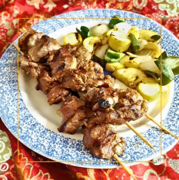 grilled beef shish kebabs on a plate with grilled vegetables