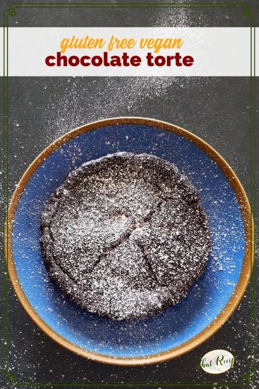 chocolate torte on a blue plate covered in powdered sugar with text "gluen free vegan chocolate torte