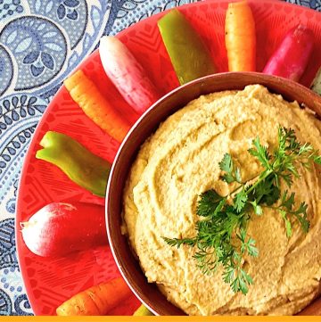 top down view of hummus surrounded by vegetables