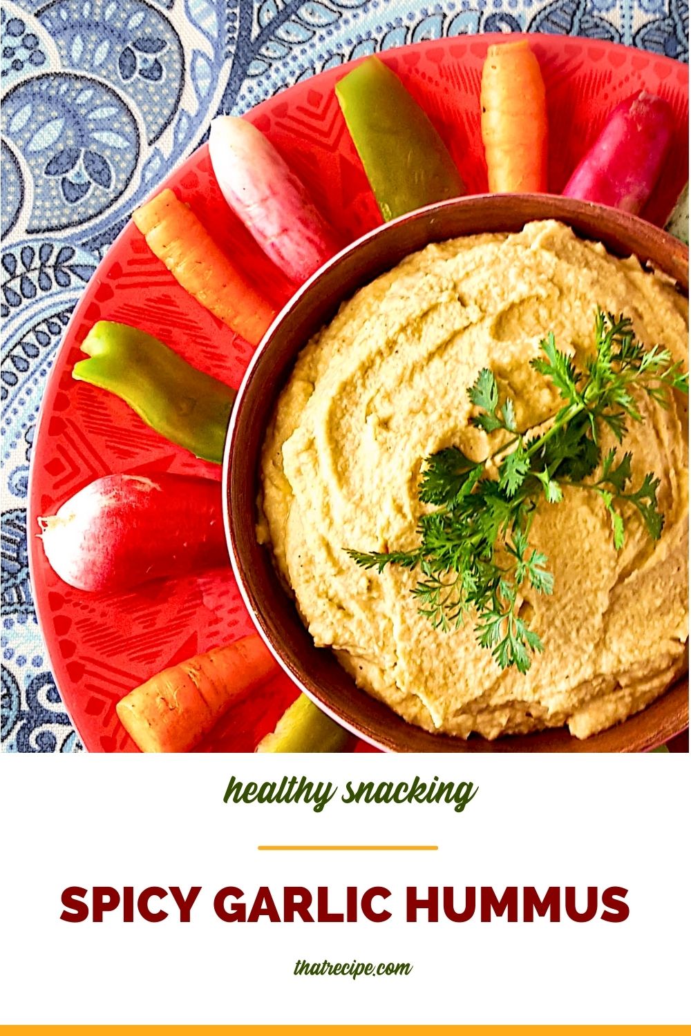 top down view of hummus surrounded by vegetables with text overlay "spicy garlic hummus"