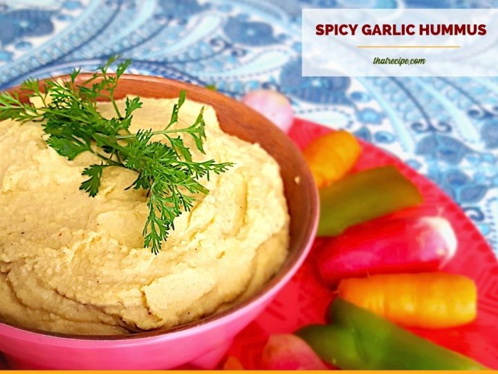 bowl of hummus surrounded by vegetables with text overlay "spicy garlic hummus"
