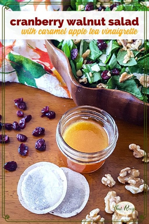 salad dressing in a jar with cranberries, walnuts, tea bags and a salad bowl around it and text overlay "cranberry walnut salad with caramel apple tea dressing"