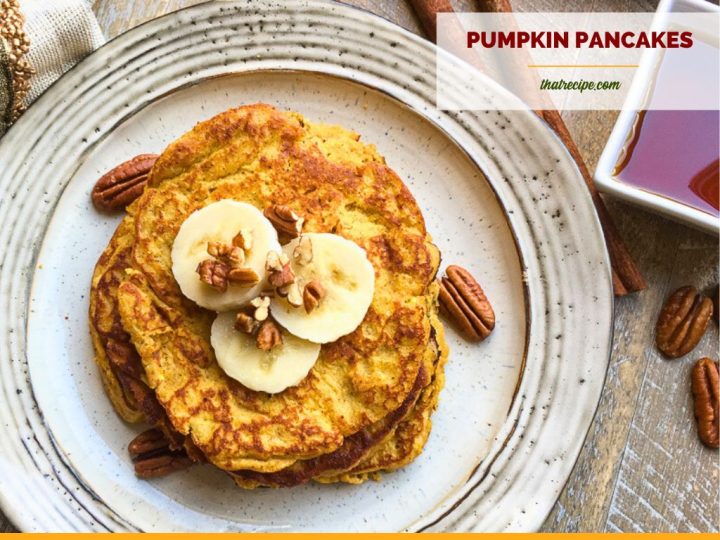 top down view of pancakes on a plate topped with pecans and banana slices and text overlay "gluten free pumpkin pancakes"