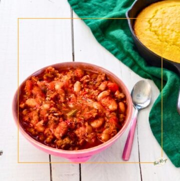 bowl of chili in front of pan of cornbread