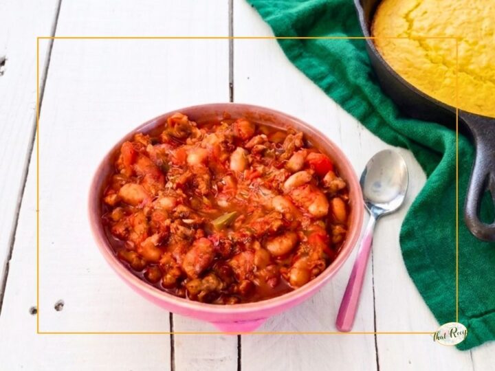 bowl of chili in front of pan of cornbread