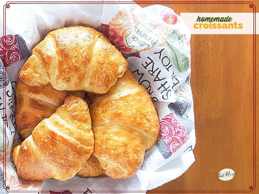 top down view of croissants in a basket with text overlay "homemade croissants"
