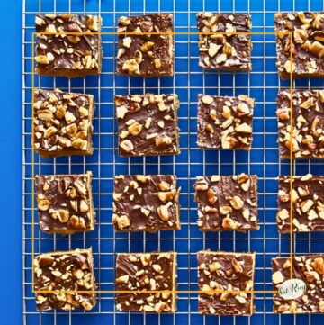 chocolate and nut topped cookie bars on a cooling rack