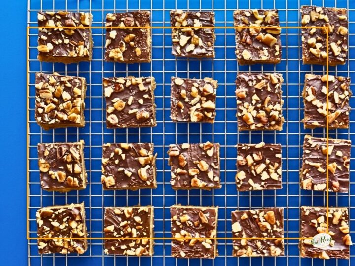 chocolate and nut topped cookie bars on a cooling rack