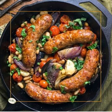 top down view of italian sausages and beans in a cast iron skillet