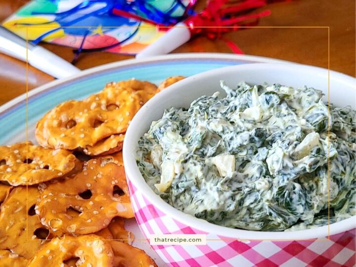 spinach dip in a bowl with pretzel crackers around it