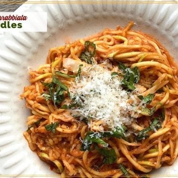 zucchini noodles with pasta sauce and parmesan on a plate with text overlay "spicy Arrabbiata Zoodles"