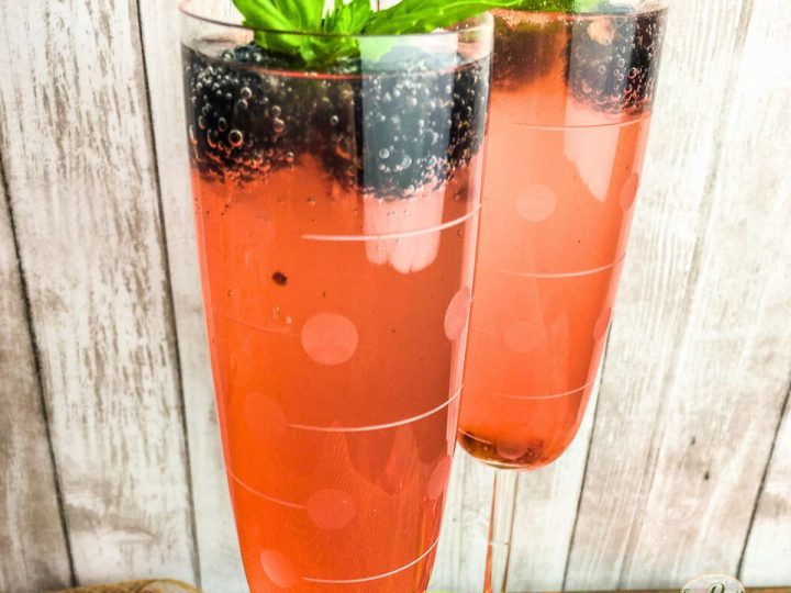 glass of pink sparkling punch with blackberries and basil