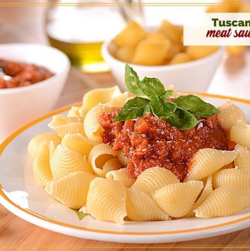 pasta with meat sauce on a plate with text overlay "tuscan meat sauce"