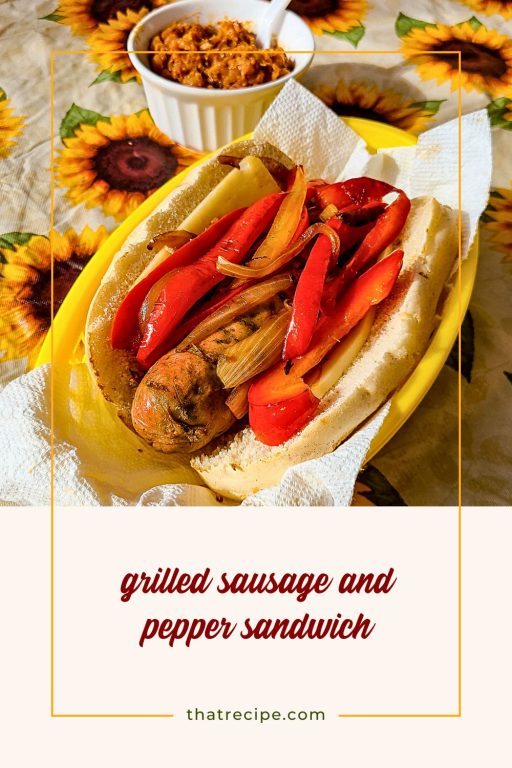Italian sausage and pepper sandwich on a table with baked beans