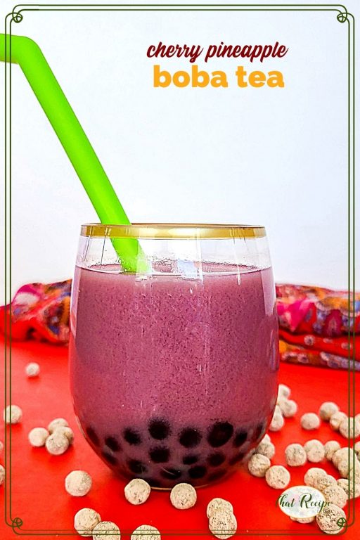 glass of bubble tea surrounded by uncooked tapioca pearls and text overlay "cherry pineapple boba tea"