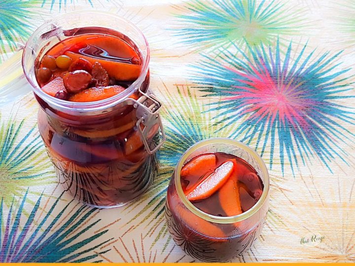 top down view of rum covered fruit in a jar and a glass