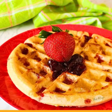 waffle topped with strawberry and jam and text overlay "crispy homemade sourdough waffles"
