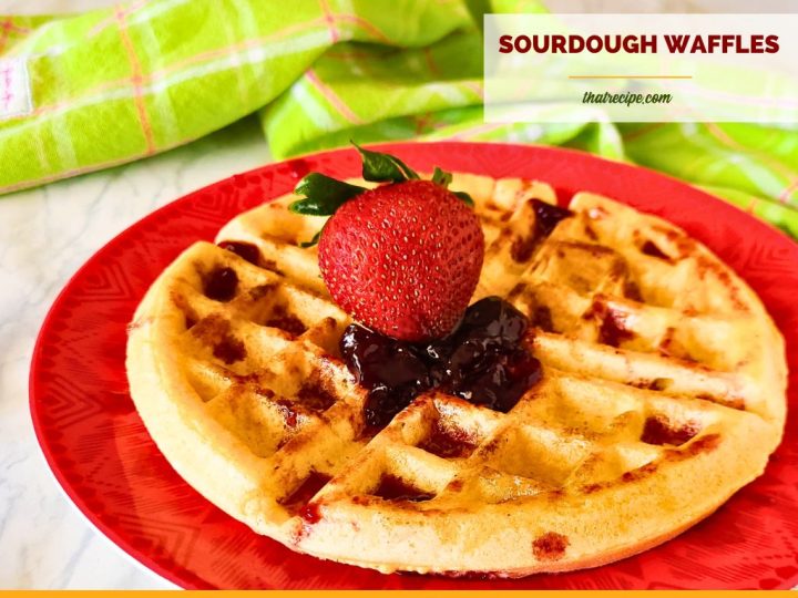 waffle topped with strawberry and jam and text overlay "crispy homemade sourdough waffles"