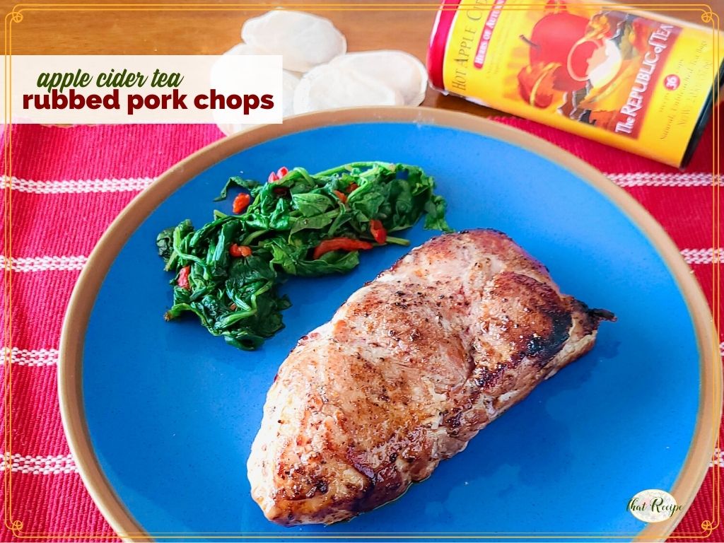 pork chop on a plate with greens and text overlay "apple cider tea rubbed pork chops"